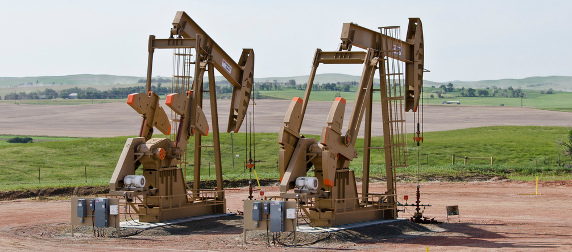 two oil well rigs in a North Dakota landscape