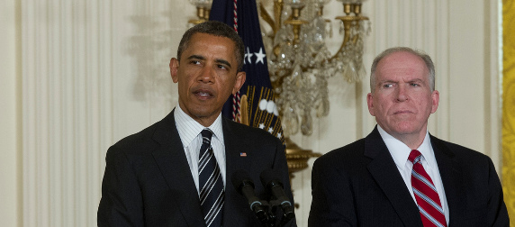 President Obama at a podium with CIA Director John Brennan standing to his left