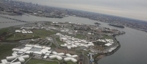 aerial view of Rikers Island, with New York City skyline in the background