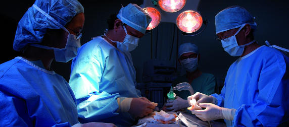 medical professionals in surgical scrubs performing a kidney transplant