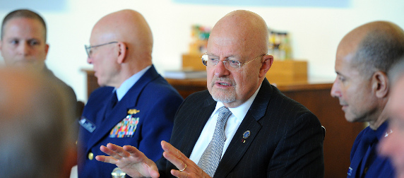 James Clapper, seated at a table with Coast Guard officials