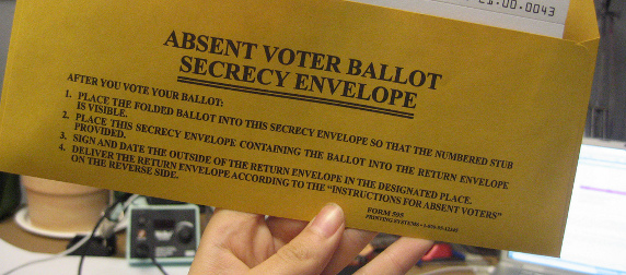 absentee ballot envelope, held up to display instructions on the back