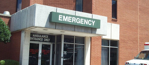 exterior emergency room entrance, marked with a large sign that reads 'Emergency'