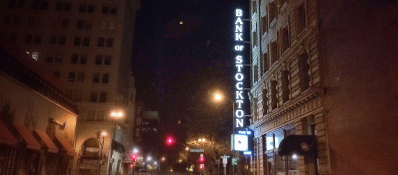 night view of a Stockton, California street including an illuminated sign for the Bank of Stockton