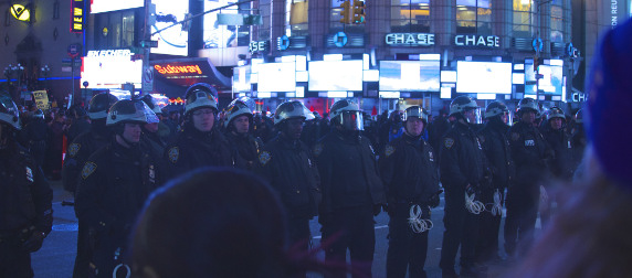 line of NYPD officers face protestors in Times Square