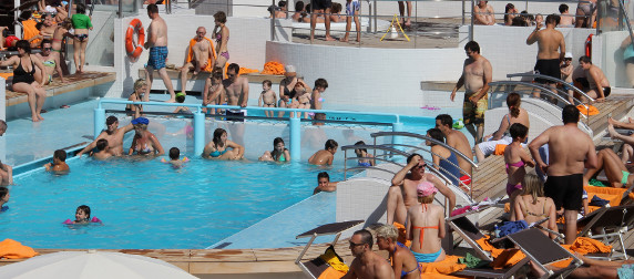 passengers in and around an on-deck cruise ship pool