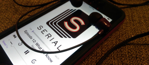 iPhone playing episode 12 of Serial, with earbuds draped over the screen