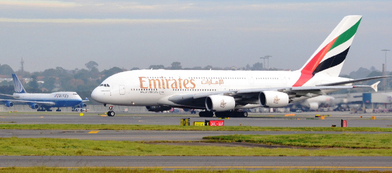 taxiing Emirates A380 jet, with a United airliner in the background