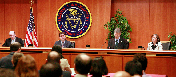 panel seated in front of the FCC seal, viewed from the audience perspective