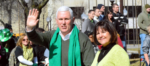 Mike Pence, waving, and Karen Pence at a St. Patrick's Day parade