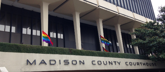 exterior of Montgomery County, Alabama court house, flying several rainbow flags