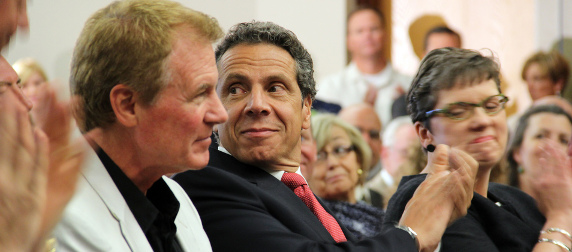 Gov. Andrew Cuomo applauding while looking over his shoulder