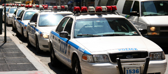 line of parked NYPD sedans by a curb