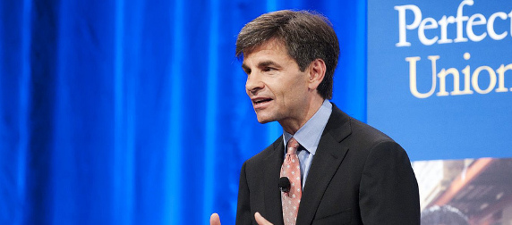 George Stephanopoulos speaking in front of a blue background