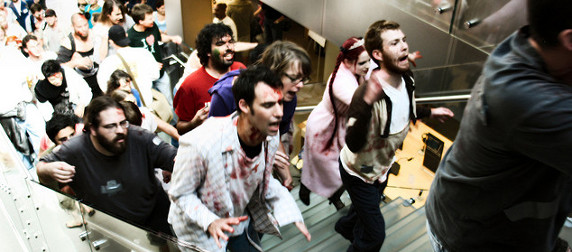 shoppers in zombie costumes and makeup ascending stairs at an Apple store