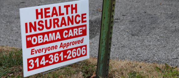 yard sign that reads Health Insurance, Obama Care, Everyone Approved, and a phone number