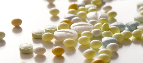 macro image of various pills on a white background