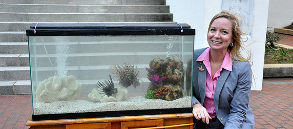 State Rep. Holly Raschein posing next to an aquarium with lionfish