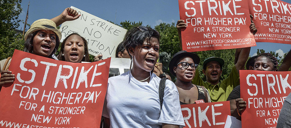 protesters holding signs that read 'Strike For Higher Pay For A Stronger New York'