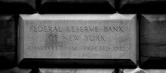 black and white image of a brick, engraved with 'Federal Reserve Bank of New York, Chartered 1914, Erected 1922'