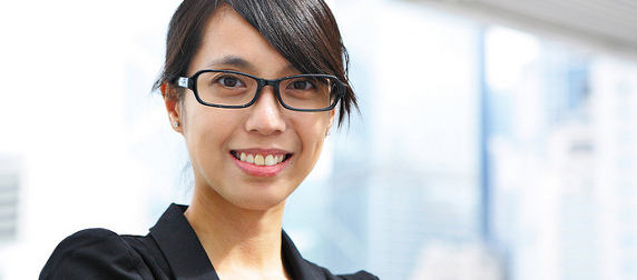 businesswoman with glasses against a pale, out-of-focus background