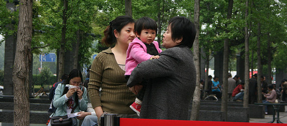 two women holding a baby in a park in Hangzhou