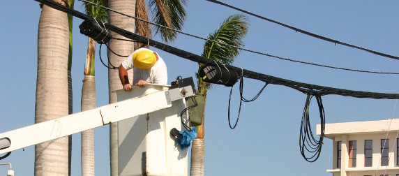 electric company worker in bucket truck inspecting power lines