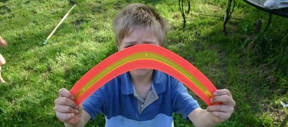 child holding up a toy boomerang