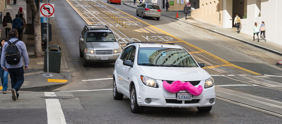 white sedan with pink Lyft moustache