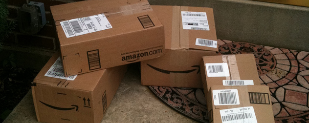 stack of Amazon delivery boxes on a home's doorstep