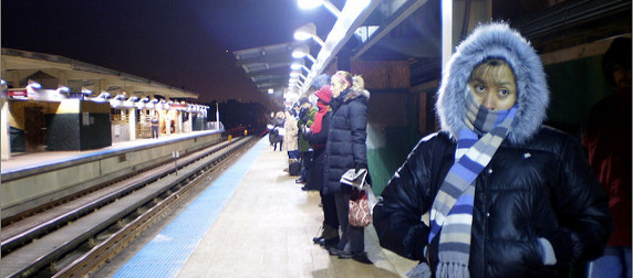 commuters dressed for cold weather waiting on a train platform in Chicago