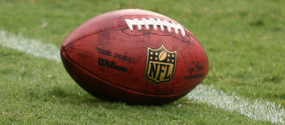 Wilson football, with NFL logo, on a field of grass