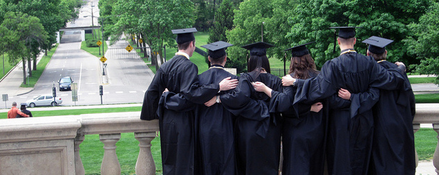 students dressed for graduation, standing together facing away from the camera