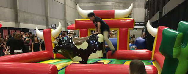 a rider attempting to mount an indoor mechanical bull at CVX Live