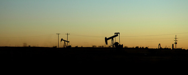 Sunset with an oil well silhouetted against the horizon