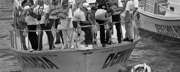 black-and-white image of activists on a boat decorated with American flags