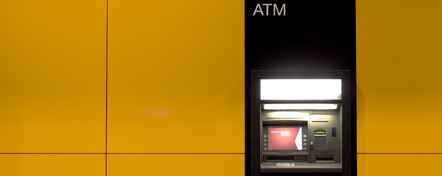 ATM with no bank affiliation embedded in a yellow wall