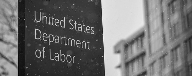 black-and-white image of a sign reading United States Department of Labor in the snow, Labor Department out of focus in the background