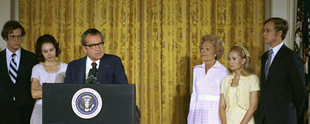 Richard Nixon delivering remarks at a White House podium, surrounded by his wife, daughters and sons-in-law