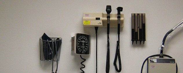 medical instruments on wall, including a blood pressure monitor, an otoscope and an ophthalmoscope