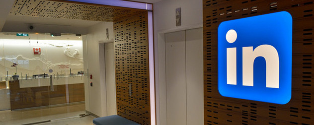 LinkedIn logo on a wall beside an elevator leading to an office reception area