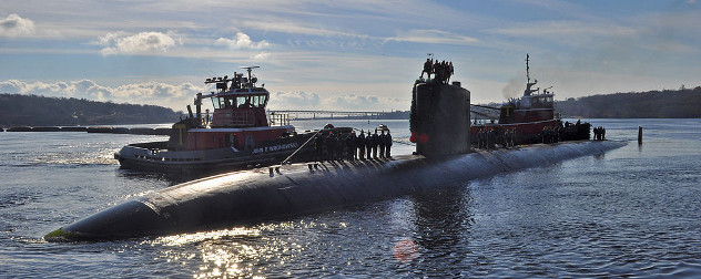  Two tugboats push the naval submarine the USS Alexandria into a pier