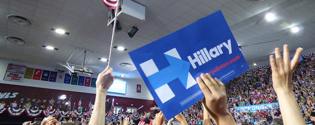 Hillary Clinton campaign sign held aloft in front of a crowd at a rally