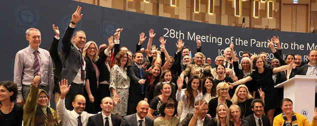 delegates to the 28th Meeting of Parties to the Montreal Protocol waving and smiling