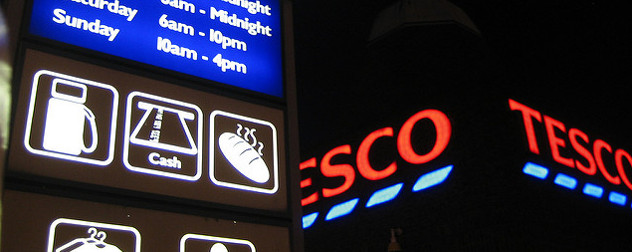 illuminated Tesco sign including icons indicating gasoline, ATM and bakery services are offered