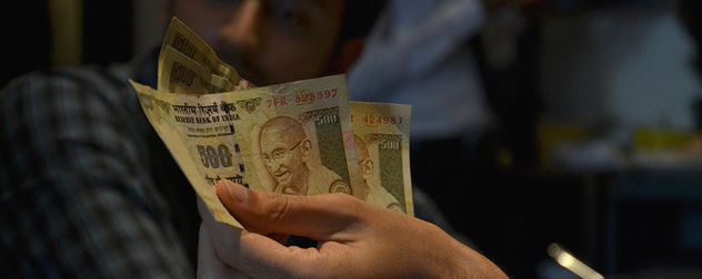 hand holding three 500-rupee notes