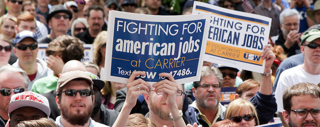 protesters at a rally, one holding a sign that reads Fighting For American Jobs at Carrier