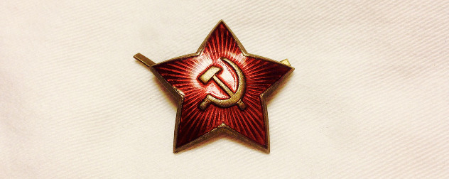 anitque Soviet pin in the shape of a star with a hammer and sickle design