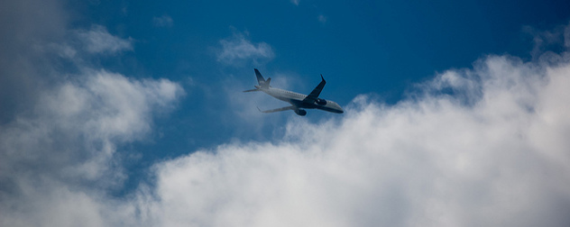 JetBlue plane among clouds, seen from below