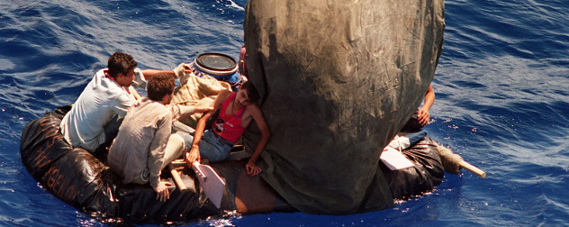 several men on a makeshift raft on the open ocean